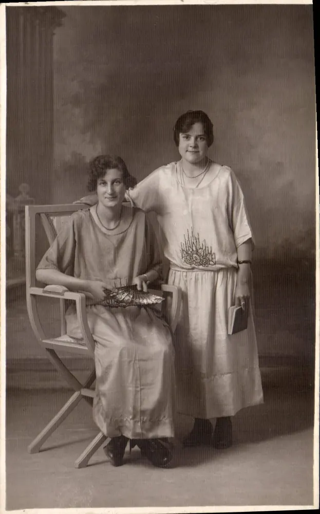 दो युवा महिलाएं — फोटोग्राफिक स्टूडियो — कोई प्रकाशक या नंबर दिखाई नहीं देता - आगे