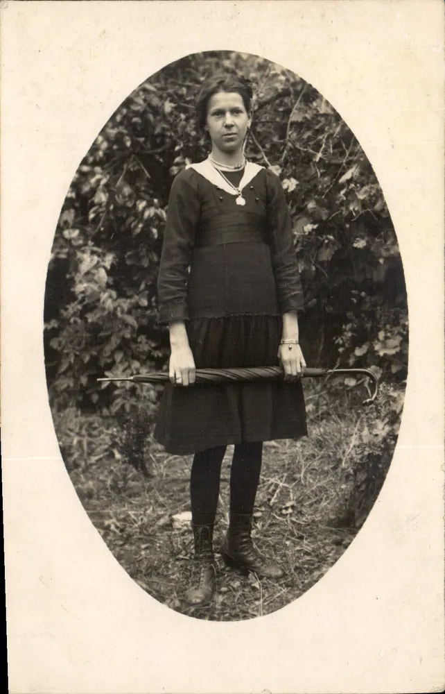 Jovem mulher com blusa de colarinho marinho — segurando um guarda-chuva fechado — fotografia de arte - Frente