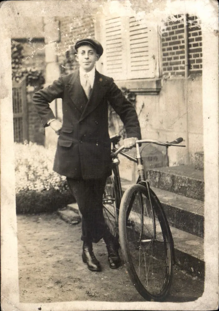 Giovane uomo con bicicletta — davanti a un edificio con persiane — editore sconosciuto - Recto