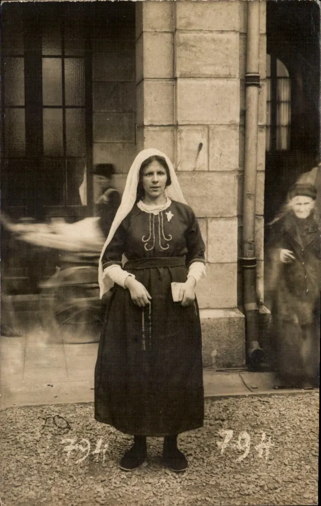 Frau im traditionellen Kleid — vor einem Gebäude — italienische Ansichtskarte - Vorderseite
