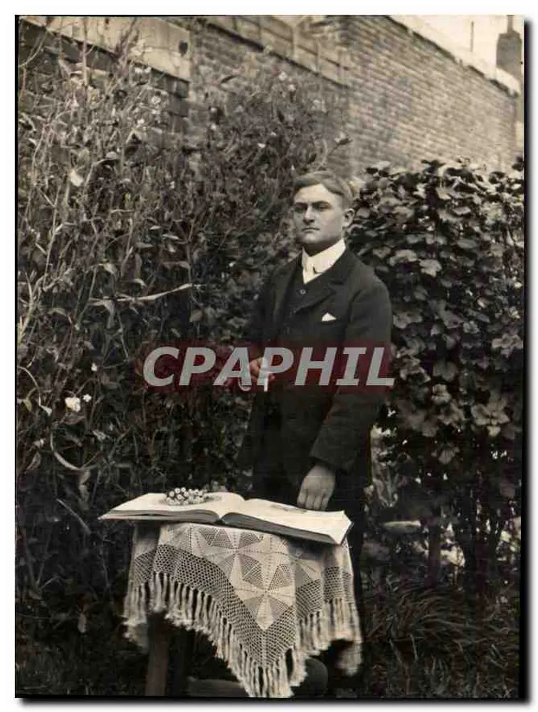 Homem de terno diante de um livro aberto — jardim — n° 1169 - Frente