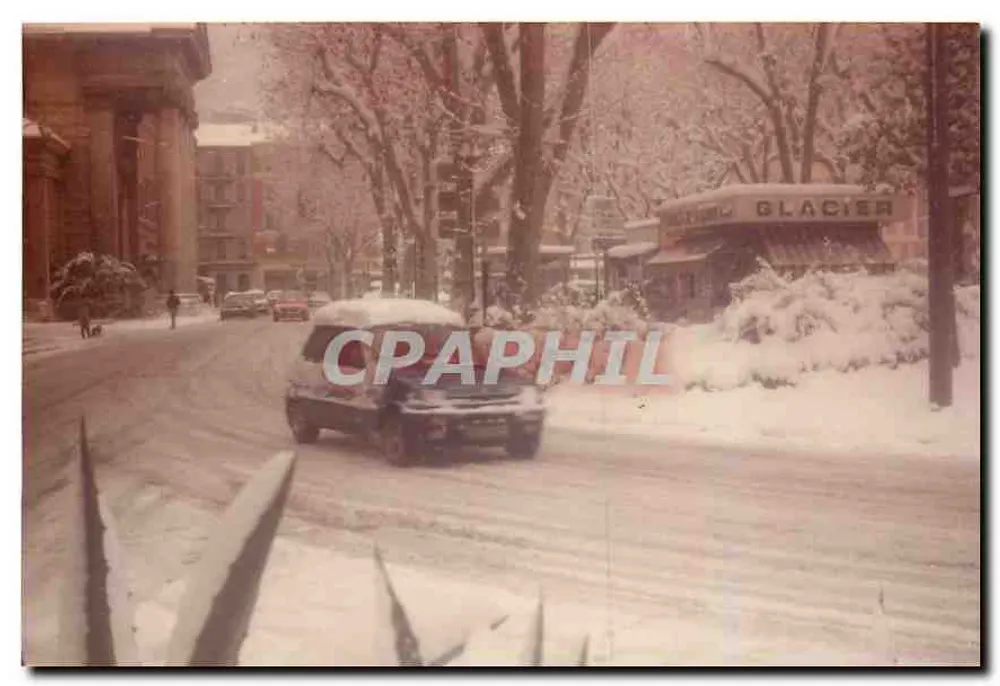 Visão de uma rua nevada — em frente a um edifício com colunas e uma loja 'GLACIER' — sem editor ou número de série visíveis - Frente