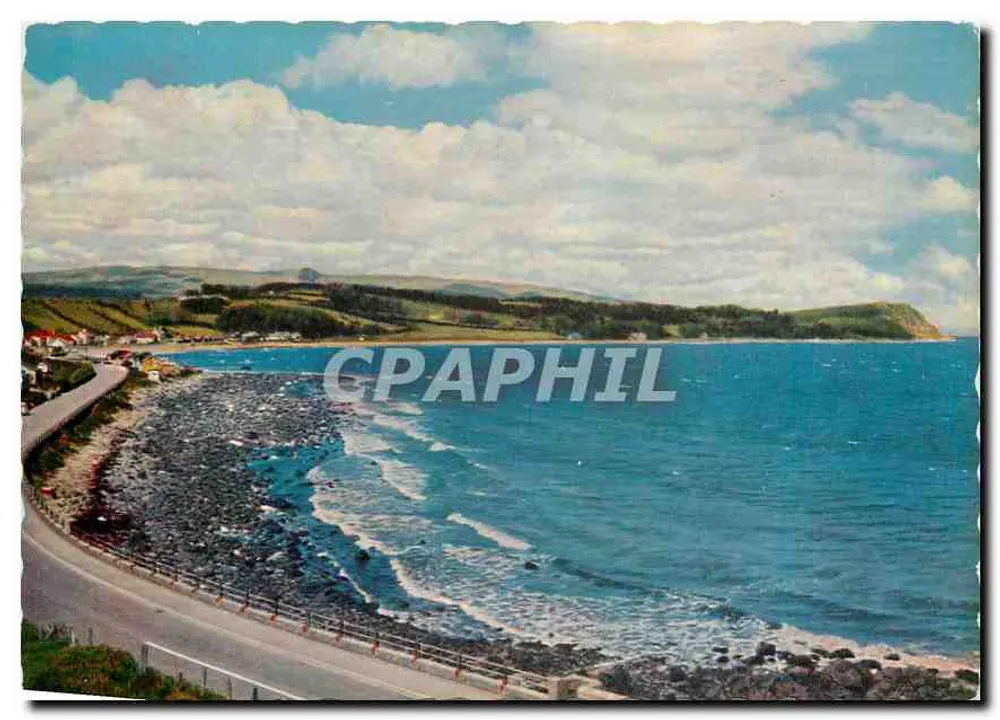 Antrim Coast Road — Entre seus vales e rios surge a montanha Slemish, onde São Patrício, como menino escravo, cuidava das ovelhas de seu senhor. Ao longo da costa de Antrim, as falésias erguem-se abruptas da estrada de um lado, enquanto o outro lado segue a margem da água. — Publicado por Valentine & Sons Ltd., Dundee. - Frente