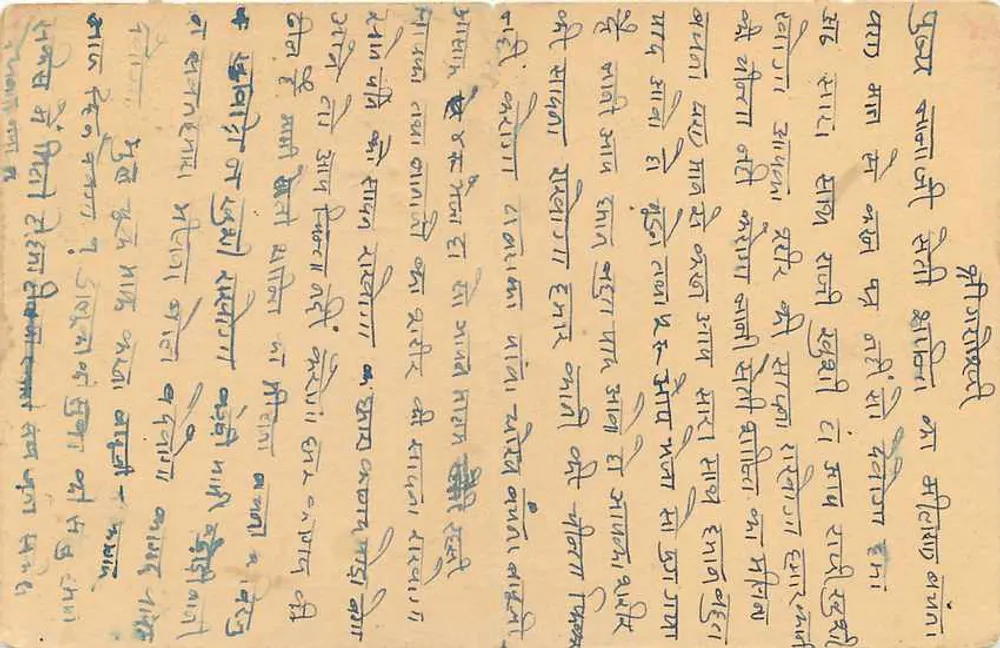 Carta postal indiana — texto em escrita devanagari — selo e datação postal - Verso