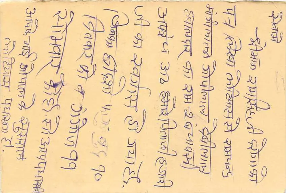 Carta postal indiana — selos de 10 e 15 annas — texto em escrita devanagari - Verso
