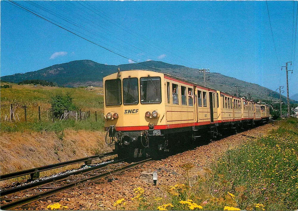 Bolquere (Pyrénées Orientales) — Ligne à voie métrique de Villefranche de Conflent à Latour de Carol — Arrivée du train jaune près du col de la Perche, juillet 1991 — Photo J.-P. Lasserre du Rozel — N° 144 - Recto