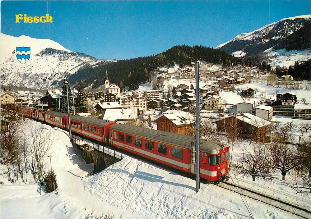Fiesch — village enneigé avec train rouge — Rud. Suter AG, Zurich - Recto