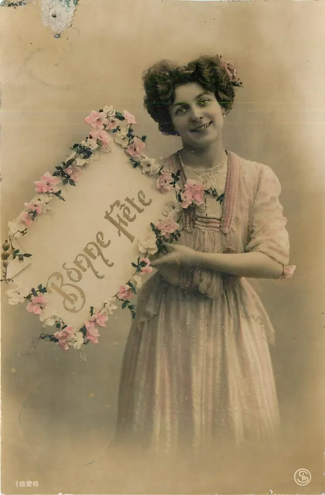 Jeune femme en robe rose — tenant un panneau floral avec 'Bonne Fête' — éditeur S, n° 1828 - Recto