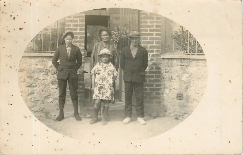 Famiglia davanti a una casa in pietra — numero di serie non visibile - Recto