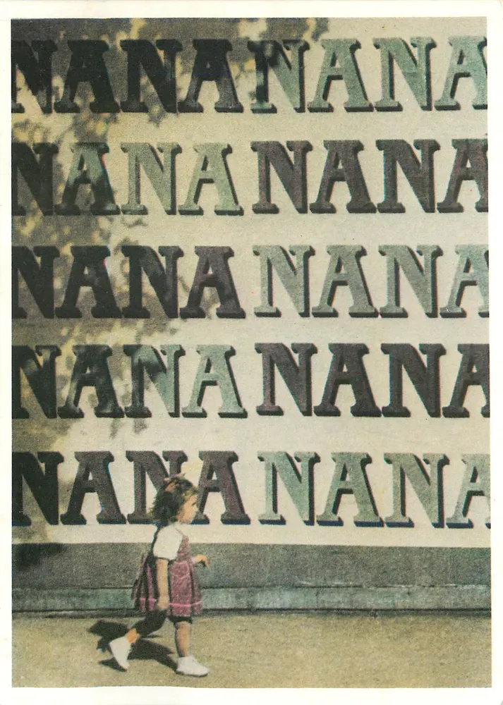 एक छोटी लड़की एक बार-बार दोहराए जाने वाले अक्षरों 'NANA' के एक दीवार के सामने — एडिशन टुशिता, सीरीज़ NA-NA MC 10 - आगे