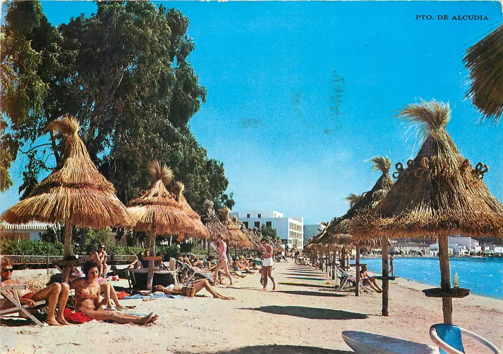 Playa de Puerto de Alcudia — vista de bañistas bajo sombrillas de paja — editor Flor de Almendro, n° 1527 - Anverso
