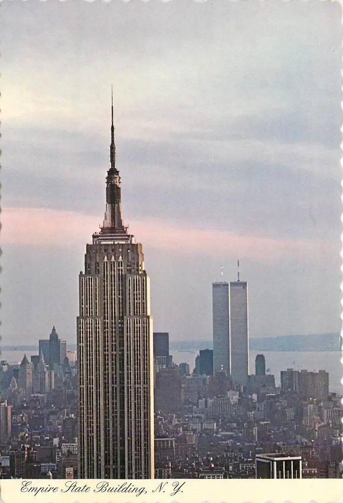 Edifício Empire State, N.Y. — vista ao entardecer com o World Trade Center no fundo — Manhattan Post Card Pub., Inc. - Frente