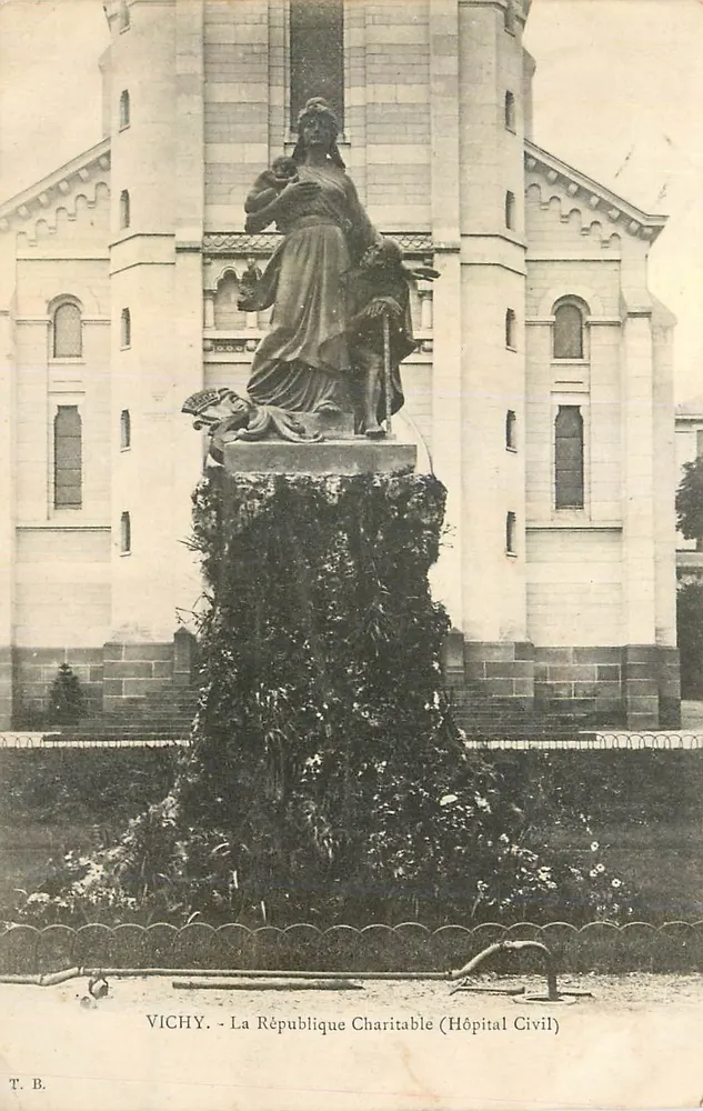 Vichy - La République Charitable (Hôpital Civil) — statue de la Charité devant un bâtiment hospitalier — T.B. - Recto