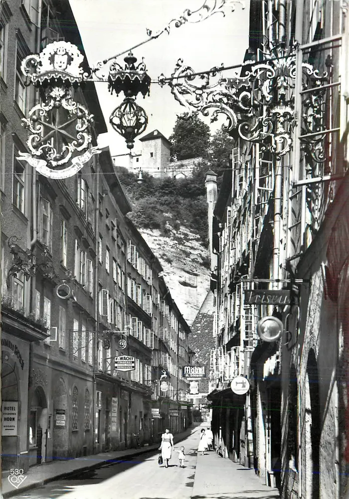 Salzburgo, Altes Stadt, Getreidegasse — vista de calle con carteles y montaña en fondo — Cosy-Verlag, Alfred Gründler, Salzburgo - Anverso