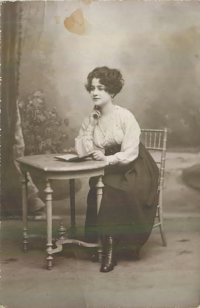 Jovem mulher sentada à mesa — estúdio — editor desconhecido - Frente
