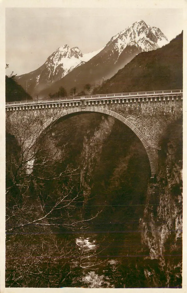 Ponte de arco sobre um canyon — montanhas nevadas no fundo — editor não identificado - Frente