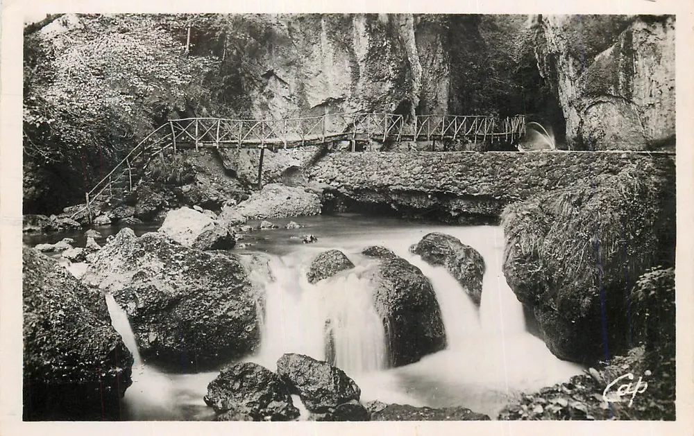 Cachoeira e ponte metálica em um cânion — Cap - Frente