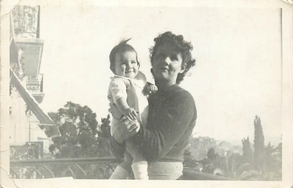 Femme tenant un bébé — balcon avec balustrade ornée — éditeur non visible - Recto