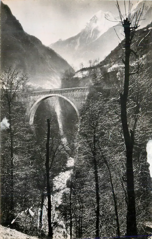 Bogenbrücke über einen schneebedeckten Bach — schneebedeckte Berge im Hintergrund — unbekannter Verleger - Vorderseite