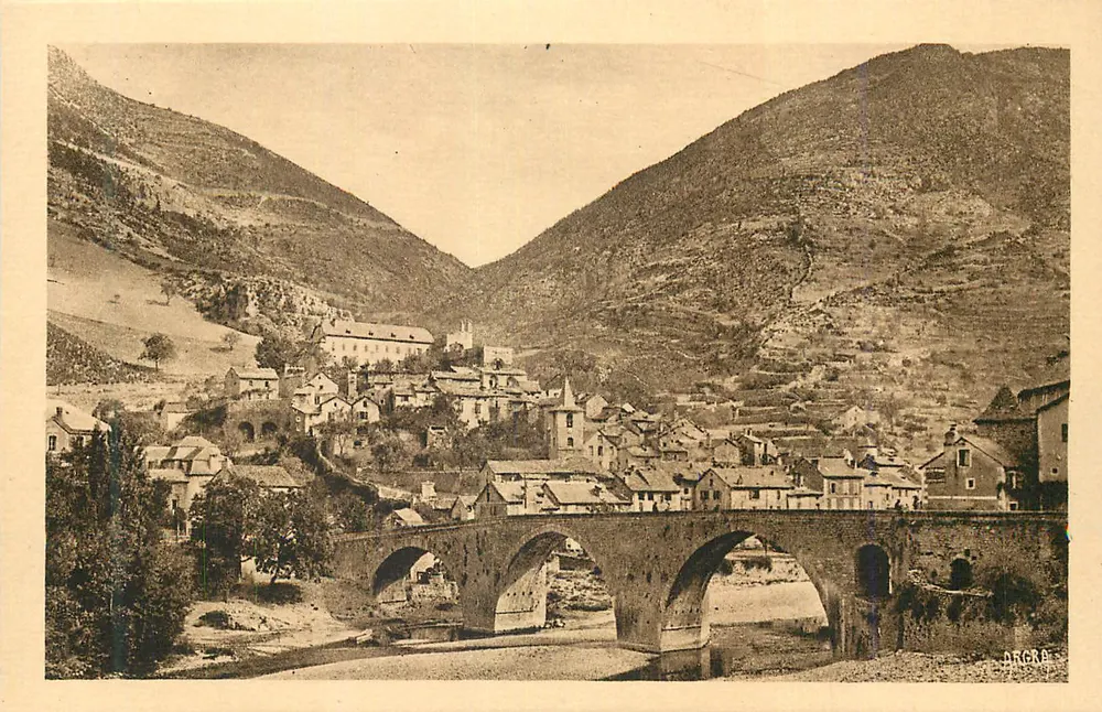 Ponte de pedra sobre o rio — aldeia encaixada entre montanhas — editor DRÈRE - Frente