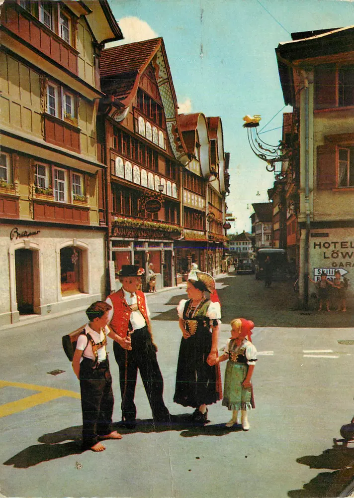 Scena uliczna w Schaffhouse — rodzina w strojach tradycyjnych — wydawca Britzner - Awers