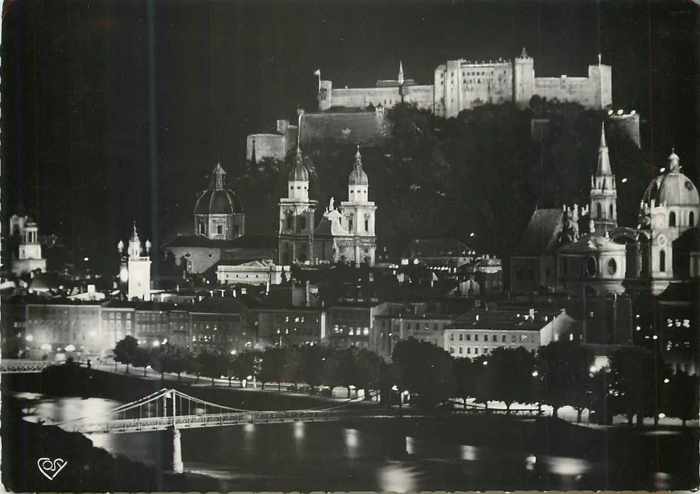 Nachtansicht der Stadt Bratislava — Schloss auf dem Hügel, Hängebrücke und beleuchtete Kirchen — Verlag 'COS' (Signatur sichtbar) - Vorderseite