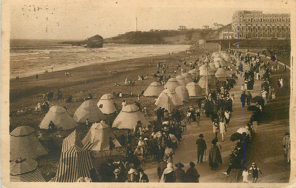 Praia animada com guarda-sóis listrados — Editor não identificável - Frente