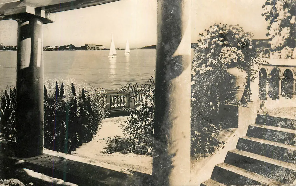 Vue do lago com barcos a vela — vista de um balcão decorado com colunas e flores — editor não visível - Frente