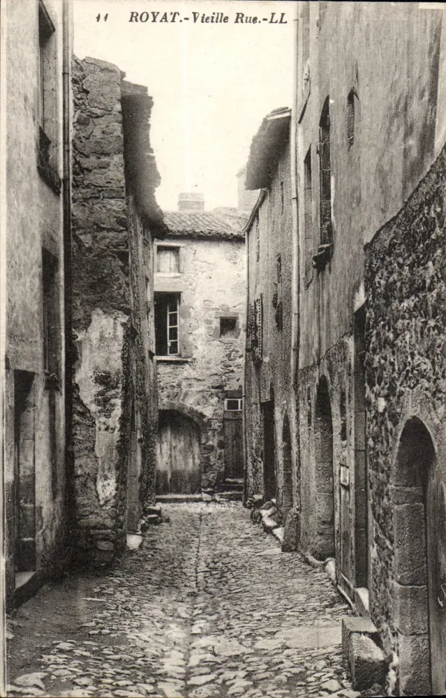 Royat - Vieille Rue — vista della strada pavimentata tra edifici in pietra - Recto