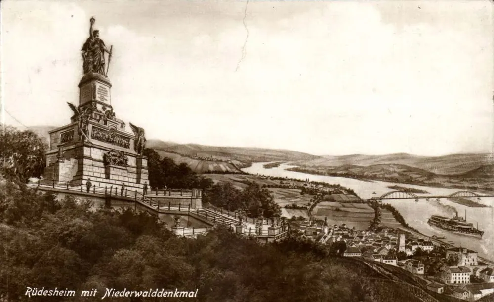 Rüdesheim mit Niederwalddenkmal — Panoramablick — unbekannter Verlag - Vorderseite