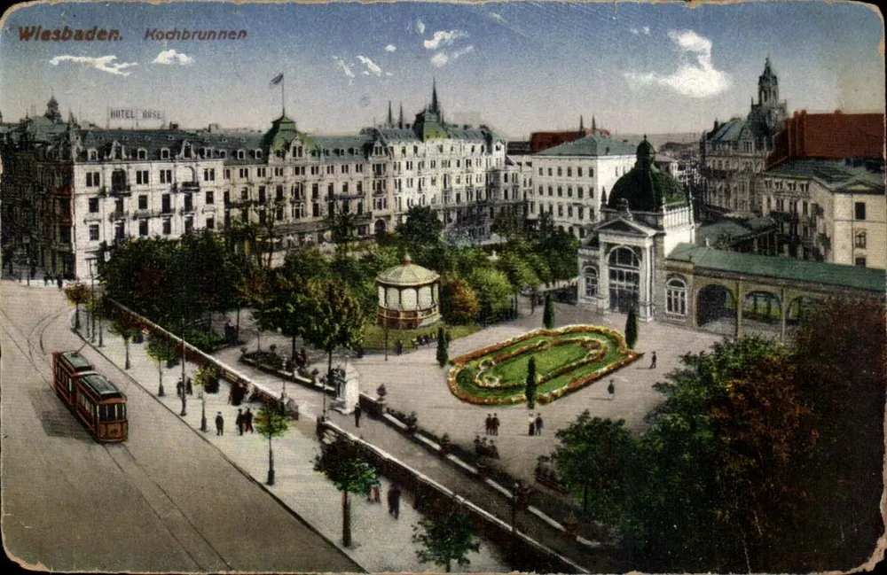Wiesbaden. Kochbrunnen — Panoramablick auf den Platz mit dem HOTEL ROSE und einer Straßenbahn — unbekannter Verleger - Vorderseite