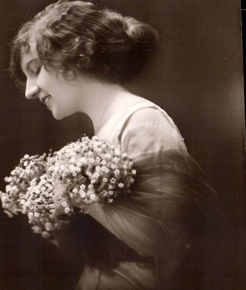 Lächelnde junge Frau mit Blumenstrauß — Photographie - Vorderseite
