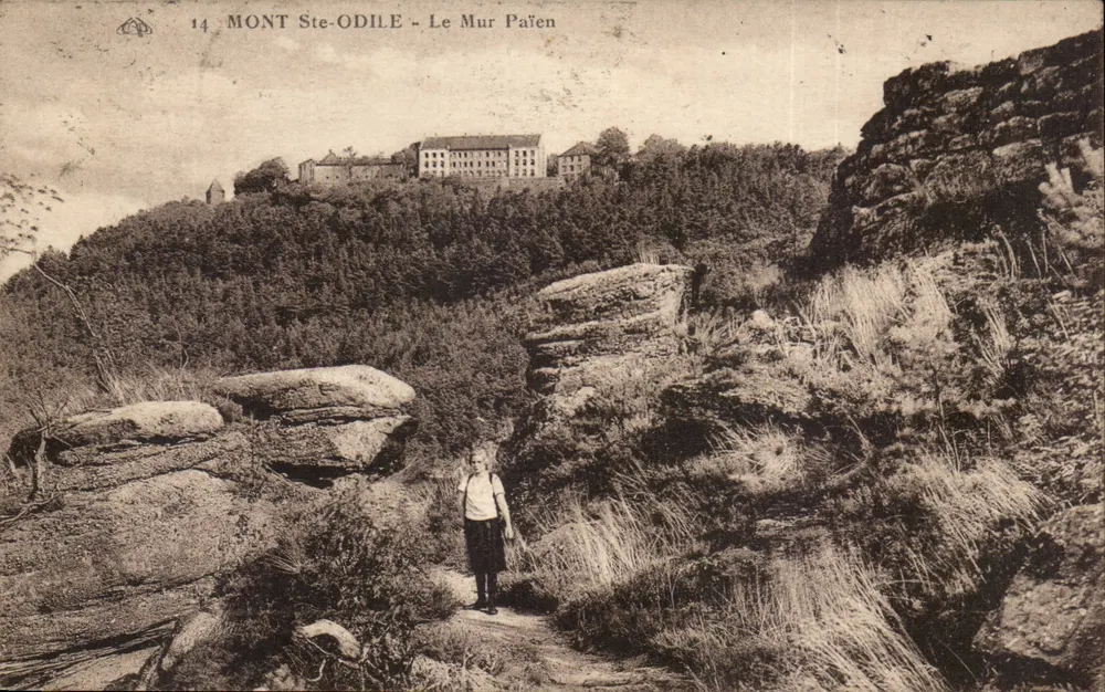 Monte Ste-Odile - Le Mur Païen — vista panoramica con edifici in alto e persona in primo piano — editore sconosciuto, n° 14 - Recto