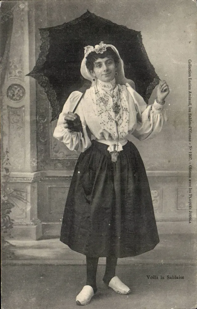 Frau im traditionellen Kleid — Pose mit schwarzem Regenschirm — Sammlung Lucien Amand, die Sablais d'Ollonne - Nr. 1207 - Vorderseite