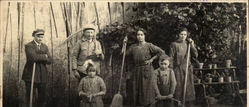 Familie oder Gruppe von Gärtner — vor einem Holzwand und Pflanzen — unbekannter Verlag - Vorderseite