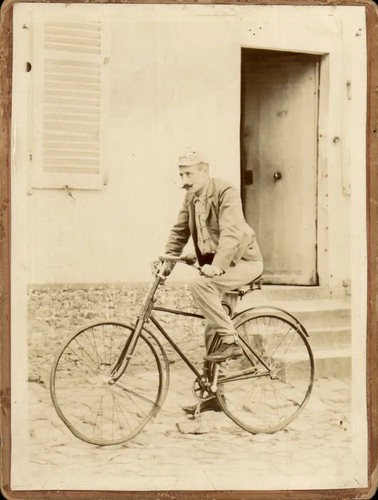 Man op fiets — voor een deur en een venster met rollo's — - Voorkant