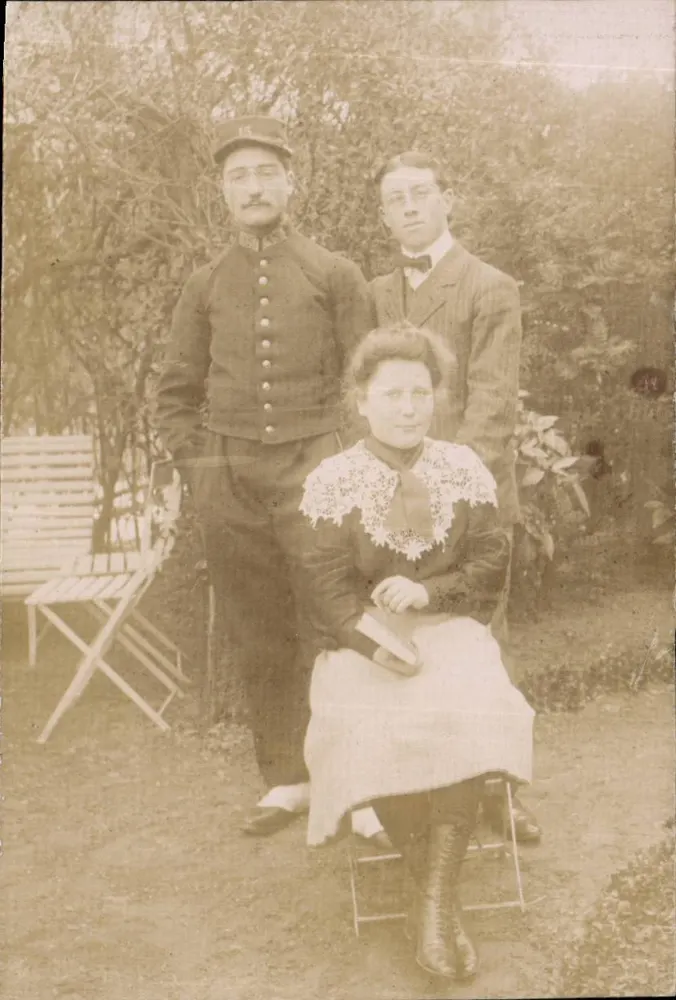 Família ou amigos no jardim — soldado em uniforme, jovem em traje, mulher sentada — sem editor ou número visível - Frente