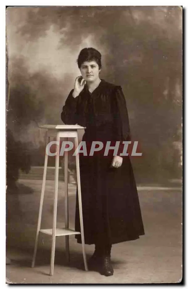 Mulher em vestido preto — pose diante de um taburete — editor desconhecido - Frente
