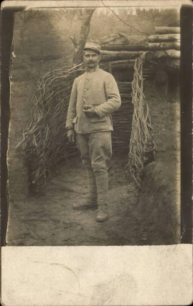 Soldat in Uniform — vor einer Holzschütze — Ansichtskarte vom 26. Oktober 1915 - Vorderseite