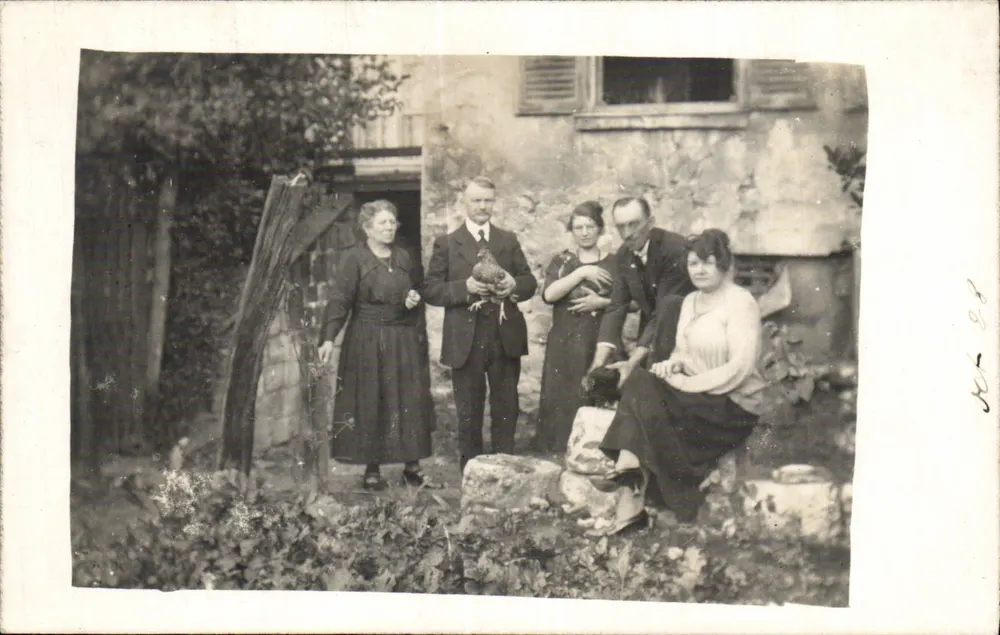 Familiengruppe mit Huhn — vor rustikalem Haus — n° 202 - Vorderseite