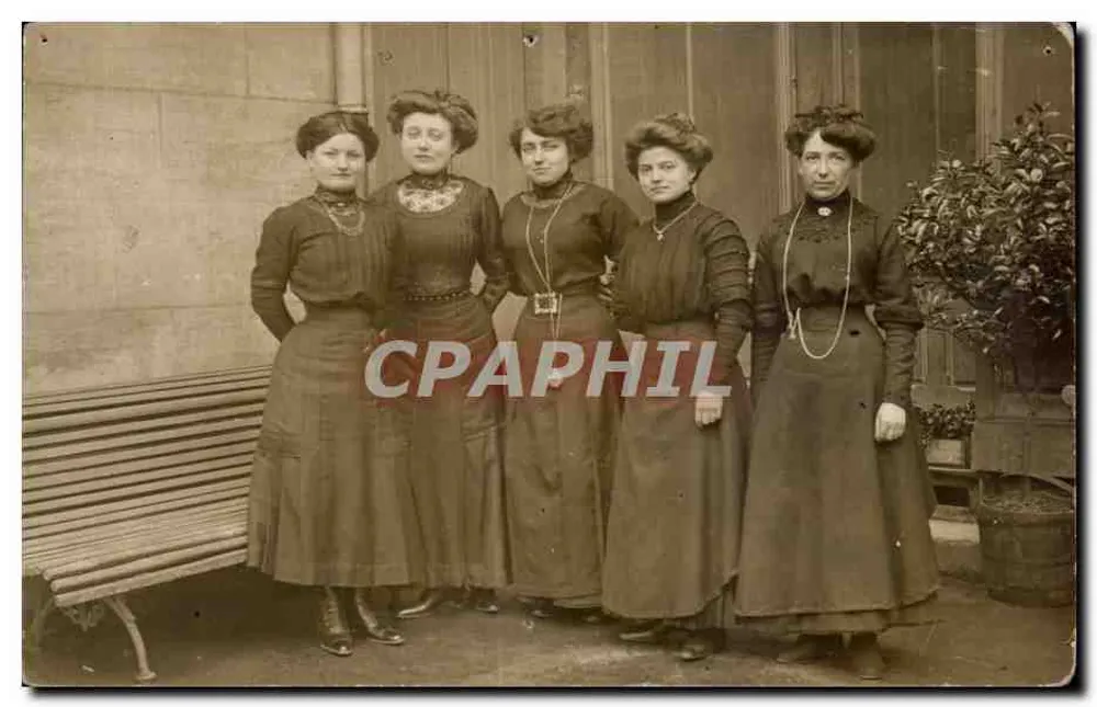 Cinco mulheres em traje da época — pose diante de um banco — sem editor ou número visível - Frente