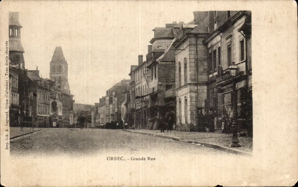 Orbéc - Grande Rue — vue de la rue avec édifice religieux en arrière-plan — éditeur A. Legrand (Calvados) - Frente