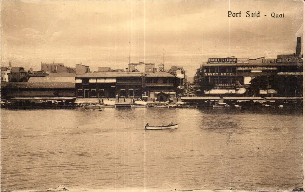 Port Said - Kai — Ansicht des Hafens mit dem Savoy Hotel und einem Boot — Verlag The Cairo Postcard Trust, Serie 208 - Vorderseite