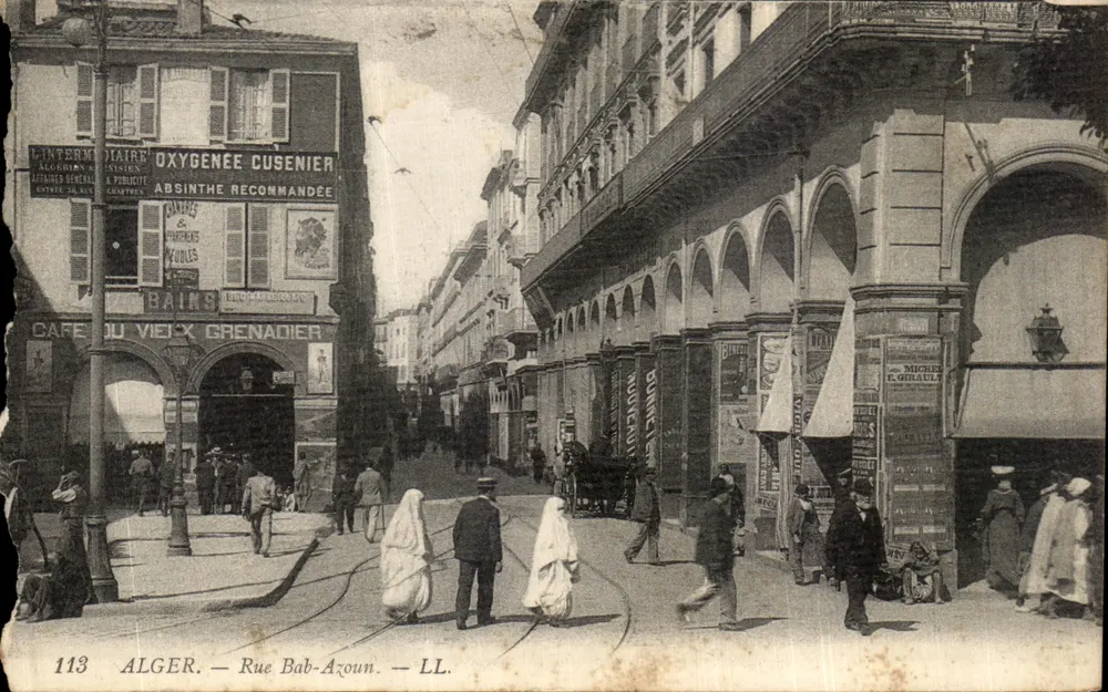 Algér - Rue Bab-Azoun — vue de la rue avec enseignes commerciales et passants, éditeur LL. n°113 - Frente