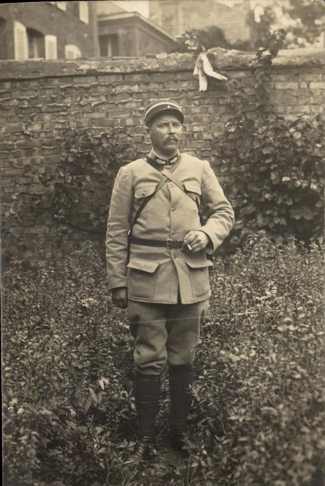 Soldat in Uniform — vor einem Mauerwerk aus Ziegeln — Ansichtskarte - Vorderseite