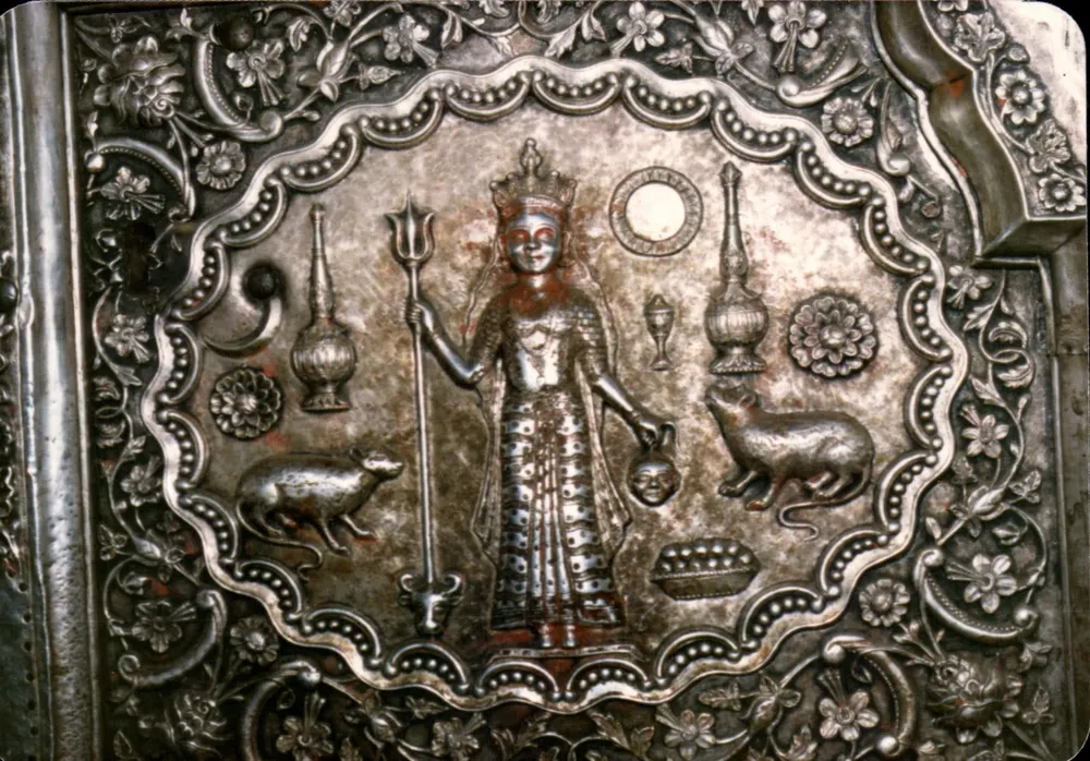 धातु के एक वस्तु के विवरण — हिंदू देवी जिसके हाथ में त्रिशूल और जानवर - आगे