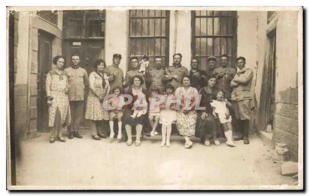 Grupo de soldados e civis — em frente a um prédio com janelas gradeadas - Frente