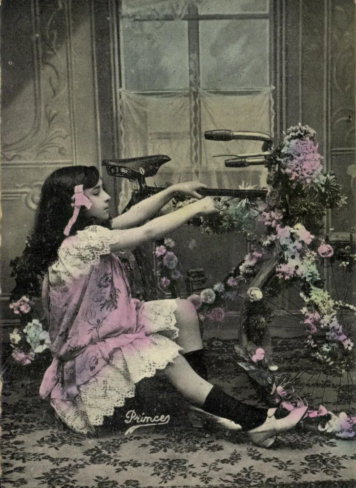 Mädchen, das mit einem blumengeschmückten Fahrrad spielt — Princes, Verlag - Vorderseite