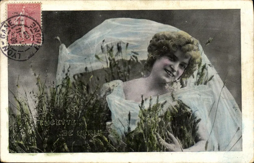 Lucette de Verly — junge Frau in weißem Kleid und Schleier auf einem Feld — veröffentlicht von der Société des Cartes Postales de Lyon - Vorderseite