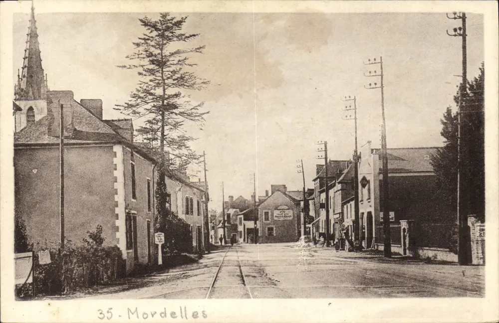 Mordelles — rue principale avec église et voies ferrées — Photo A. Dennin, Rennes - Frente